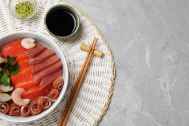 Lezzetli uskumru, karides, maydanozla servis edilen ton balığı, wasabi ve soya sosu gri mermer masada, üst görünümü yazı için alan. Lezzetli sashimi yemeği.