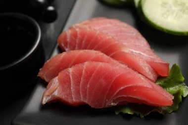 Lezzetli sashimi (taze çiğ ton balığı parçaları) siyah tabakta, yakın plan