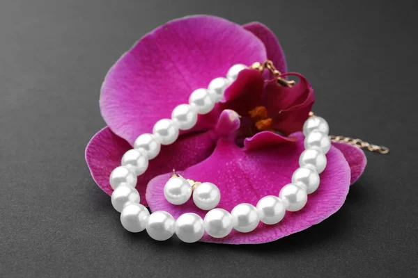 Elegantes Pendientes Perlas Pulsera Flor Orquídea Sobre Fondo Negro Primer —  Fotos de Stock