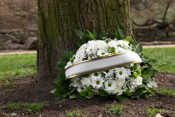 Wieniec Pogrzebowy Kwiatami Wstążką Pobliżu Drzewa Zewnątrz — Zdjęcie stockowe