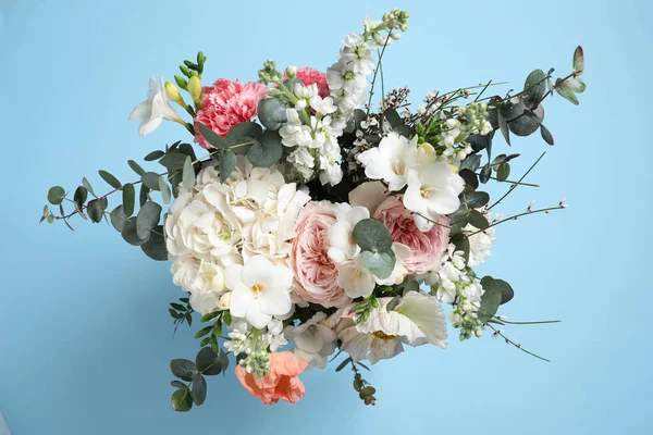 Bouquet of beautiful flowers on light blue background, top view