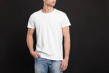 Siyah arka planda beyaz tişört giyen adam, yakın plan. Tasarım için model