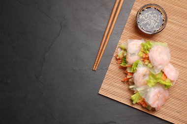 Lezzetli börekler, yemek çubukları, soya sosu ve gri desenli masa üzerinde bambu hasırı, düz yatak. Metin için boşluk