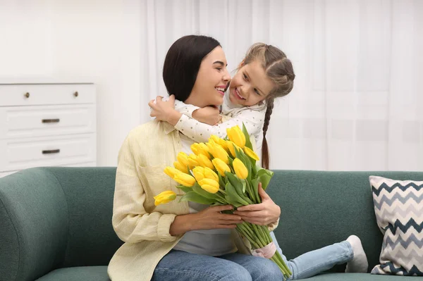Šťastná Žena Její Roztomilá Dcera Kyticí Žlutých Tulipánů Pohovce Doma — Stock fotografie