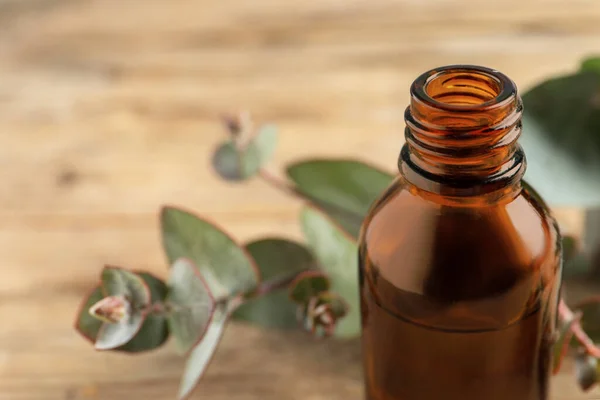 Eine Flasche Ätherisches Eukalyptusöl Und Blätter Auf Einem Holztisch Nahaufnahme — Stockfoto