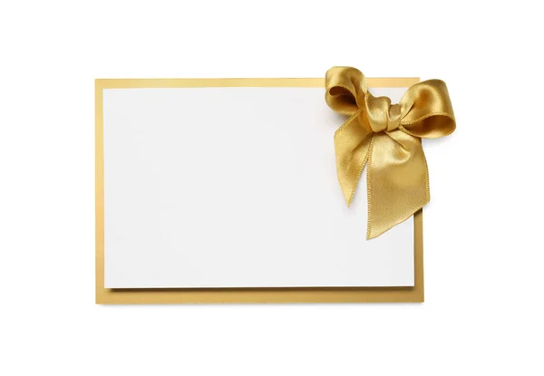 stock image Blank gift card with golden bow isolated on white, top view