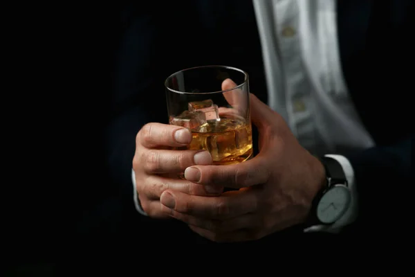 Mężczyzna Trzymający Szklankę Whisky Kostkami Lodu Czarnym Tle Zbliżenie — Zdjęcie stockowe