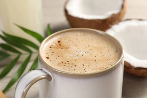 Tasse Kaffee Kokosnusshälften Und Grüne Blätter Auf Dem Tisch Nahaufnahme — Stockfoto