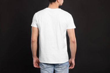 Siyah arka planda beyaz tişört giyen bir adam. Tasarım için model