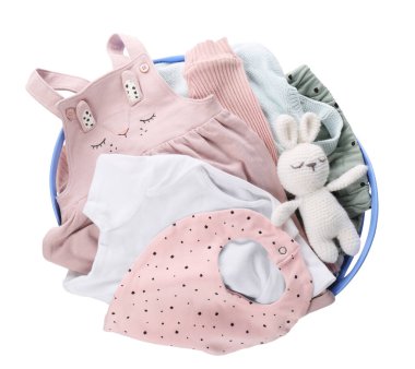 Çamaşır sepetinin içinde bebek kıyafetleri ve beyaz üzerine izole edilmiş tığ işi bir oyuncak.