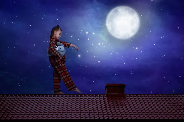 Girl holding toy and sleepwalking on roof under starry sky with full moon