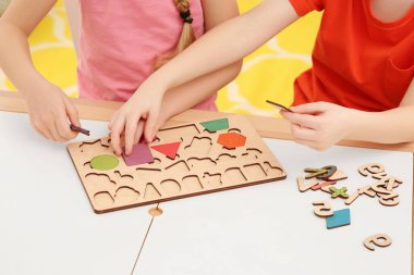 Çocuklar kapalı mekânlarda matematik setiyle oynuyorlar, yakın plan. Matematiği eğlenerek öğreniyorum.