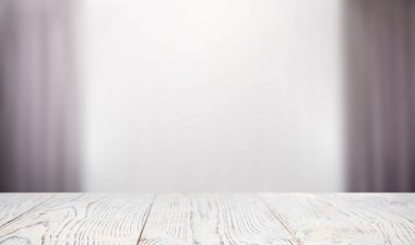 Boş beyaz ahşap masa perdelerle pencereye dayanıyor. Tasarım için boşluk
