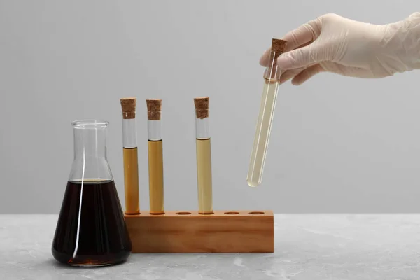 Wissenschaftler Nimmt Reagenzglas Mit Brauner Flüssigkeit Aus Ständer Auf Hellem — Stockfoto