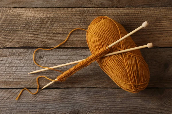 柔らかいオレンジ色の糸 編み物 木製のテーブルの針 トップビュー — ストック写真