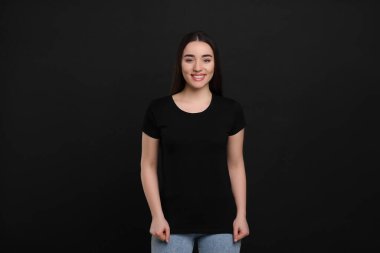 Siyah tişörtlü siyah arka planda bir kadın
