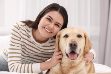 Evde tatlı Labrador Retriever 'ı olan mutlu kadın.