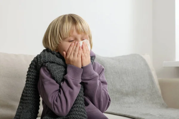 男孩在房间的沙发上用纸巾吹鼻涕 感冒症状 — 图库照片