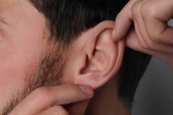 Man Touching His Ear Grey Background Closeup — Stock Photo, Image