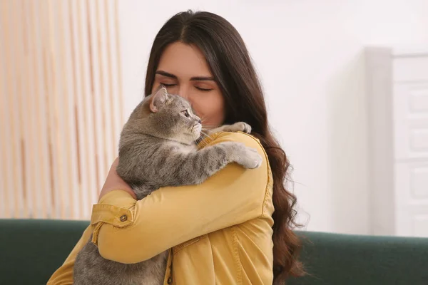 Young Woman Kissing Her Adorable Cat Home Space Text — стоковое фото