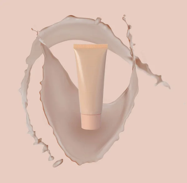 Liquid foundation in tube and splashes of makeup product on pink beige background