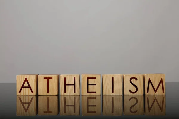 Λέξη Αθεϊσμός Από Ξύλινους Κύβους Γράμματα Στην Επιφάνεια Του Καθρέφτη — Φωτογραφία Αρχείου