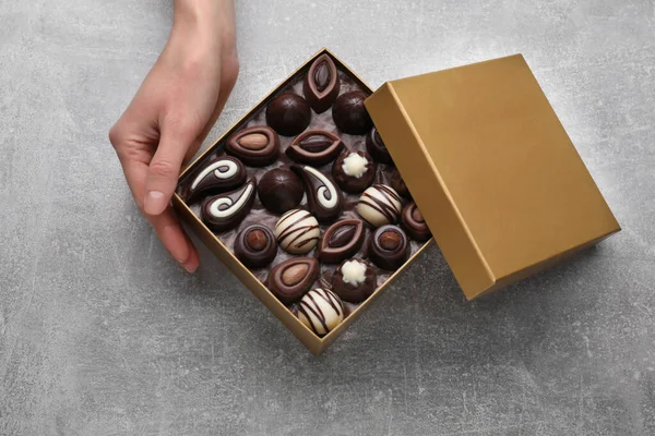 Mulher Com Caixa Aberta Deliciosos Doces Chocolate Mesa Cinza Clara — Fotografia de Stock