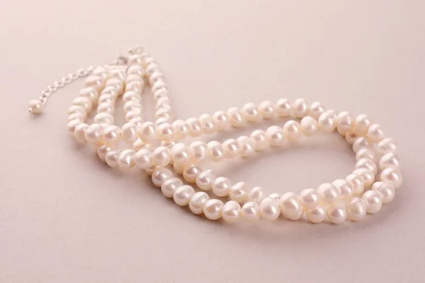 Elegante Collar Con Perlas Sobre Fondo Beige —  Fotos de Stock