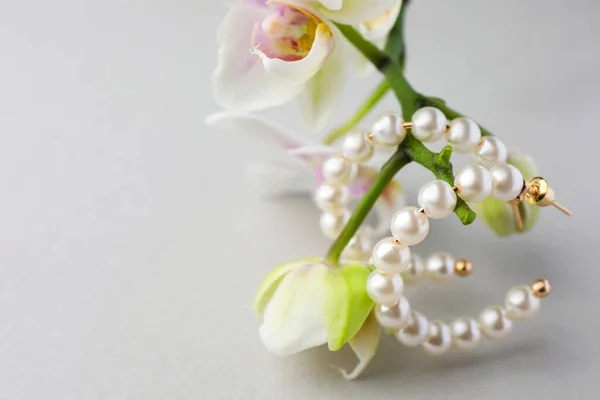 Elegante Perlenohrringe Und Orchideenblumen Auf Weißem Hintergrund Nahaufnahme Raum Für — Stockfoto