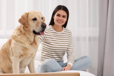 Evde tatlı Labrador Retriever 'ı olan mutlu kadın.