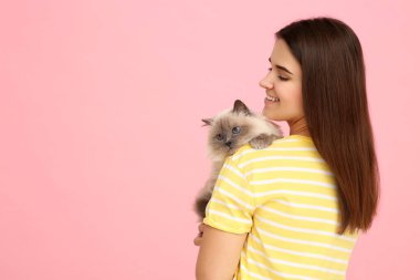 Pembe arka planda sevimli kedisi olan mutlu kadın, mesaj için yer var.