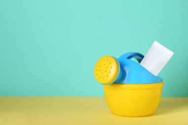 Güneş yanığı ürünü ve plastik plaj oyuncağı. Metin için boşluk