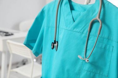 Turkuaz tıp üniforması ve steteskop klinikte, yakın plan.