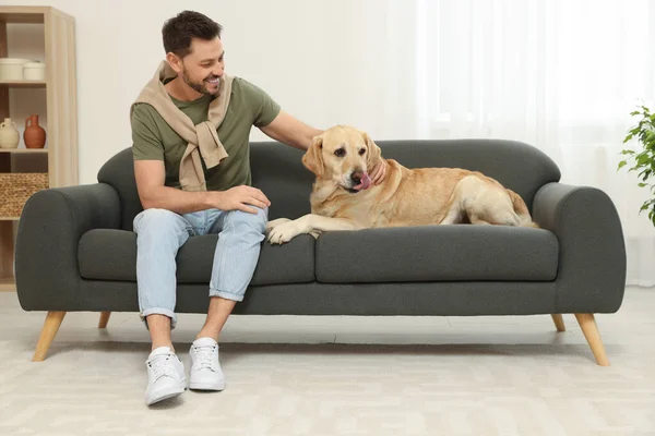 Glücklicher Mann Sitzt Mit Seinem Niedlichen Labrador Retriever Hause Auf — Stockfoto
