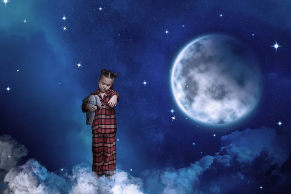 Girl holding toy and sleepwalking on clouds in starry sky with full moon