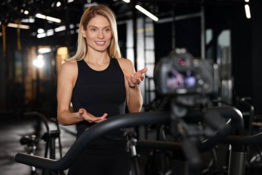 Fitness trainer recording online classes in gym