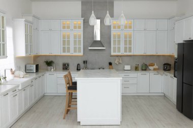 Modern mobilyaları ve farklı aletleri olan şık bir mutfak. İç tasarım