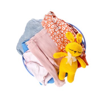 Çamaşır sepetinin içinde bebek kıyafetleri ve beyaz üzerine izole edilmiş tığ işi bir oyuncak.