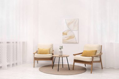 Şık koltuklar ve oturma odasındaki ahşap masa. İç tasarım