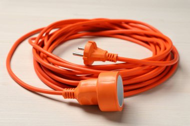Beyaz ahşap zemindeki uzatma kablosu, yakın plan. Elektrikçi ekipmanı.