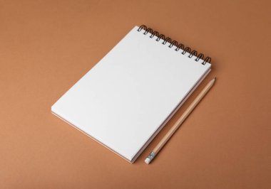 Açık kahverengi arkaplanda defter ve kalem aç