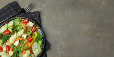 Gri masada servis edilen mercimek, peynir ve sebzeli leziz salata. Metin için alanı olan pankart tasarımı