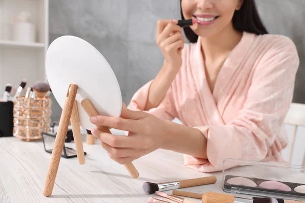 stock image Woman applying lipstick at dressing table indoors, closeup