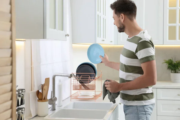 Man Putting Clean Plate Drying Rack Kitchen — Stock Photo, Image