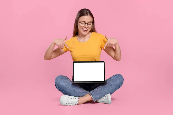 Щаслива Жінка Окулярах Вказує Ноутбук Рожевому Фоні — стокове фото