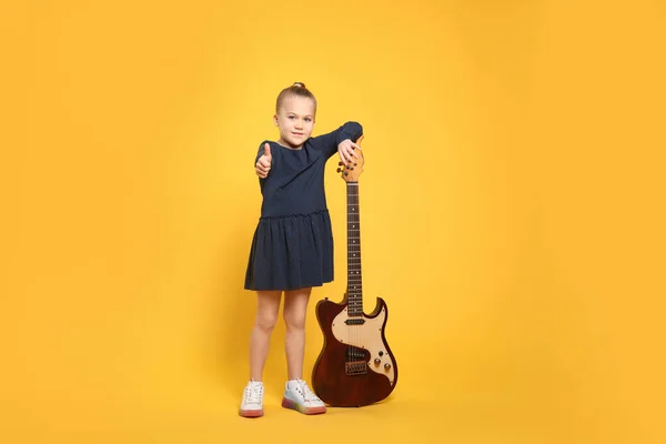 Sarı Arka Planda Elektro Gitarı Olan Mutlu Kız — Stok fotoğraf