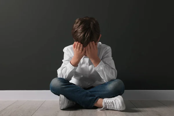 Upset Boy Sitting Floor Black Wall School Bullying — Stock Photo, Image
