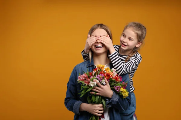 Lilla Dottern Gratulerar Sin Mamma Med Blommor Orange Bakgrund Utrymme — Stockfoto