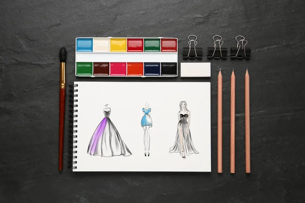 Skizzen Von Verschiedenen Kleidungsstücken Auf Schwarzem Tisch Schreibtisch Der Modedesignerin — Stockfoto