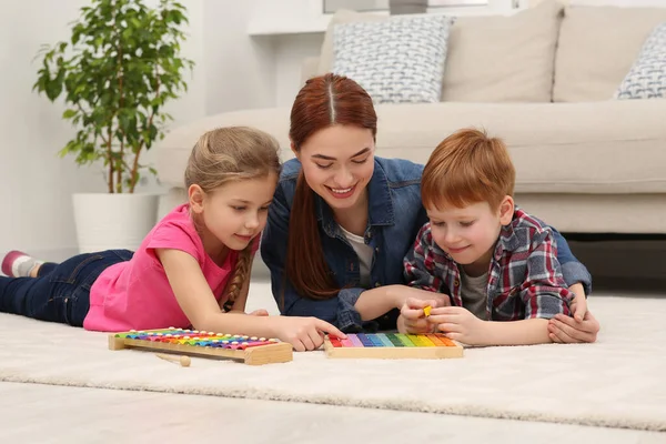 快乐的母亲和孩子们在房间的地板上玩着不同的数学游戏包 愉快地学习数学 — 图库照片